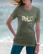 frau trägt leichtes sommer t shirt aus baumwolle in farbe earthy green mit think motiv auf der brust