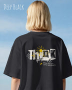 blonde frau trägt ein heavyweight oversized design-t-shirt in der farbe deep black mit dem backprint think.
