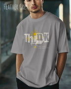 junger mann trägt ein heavyweight oversized design-t-shirt in der farbe heather grey mit dem motiv think.