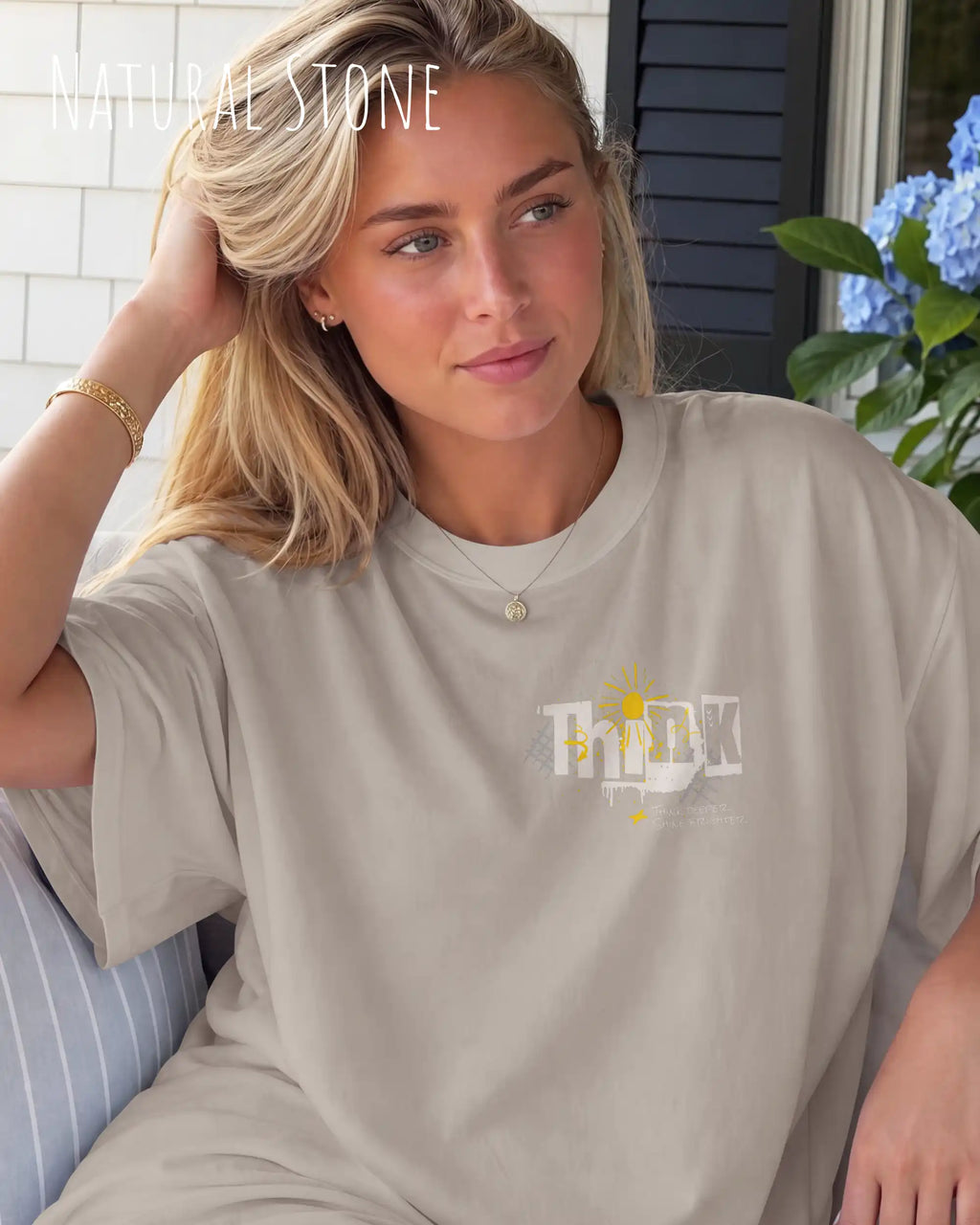 blonde frau trägt ein heavyweight oversized design-t-shirt in der farbe natural stone mit dem motiv think oben links