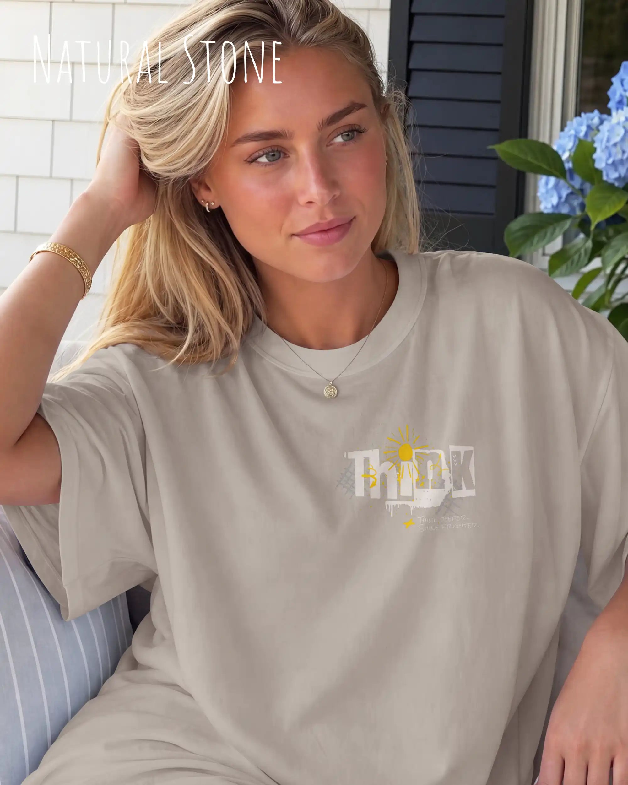 blonde frau trägt ein heavyweight oversized design-t-shirt in der farbe natural stone mit dem motiv think oben links