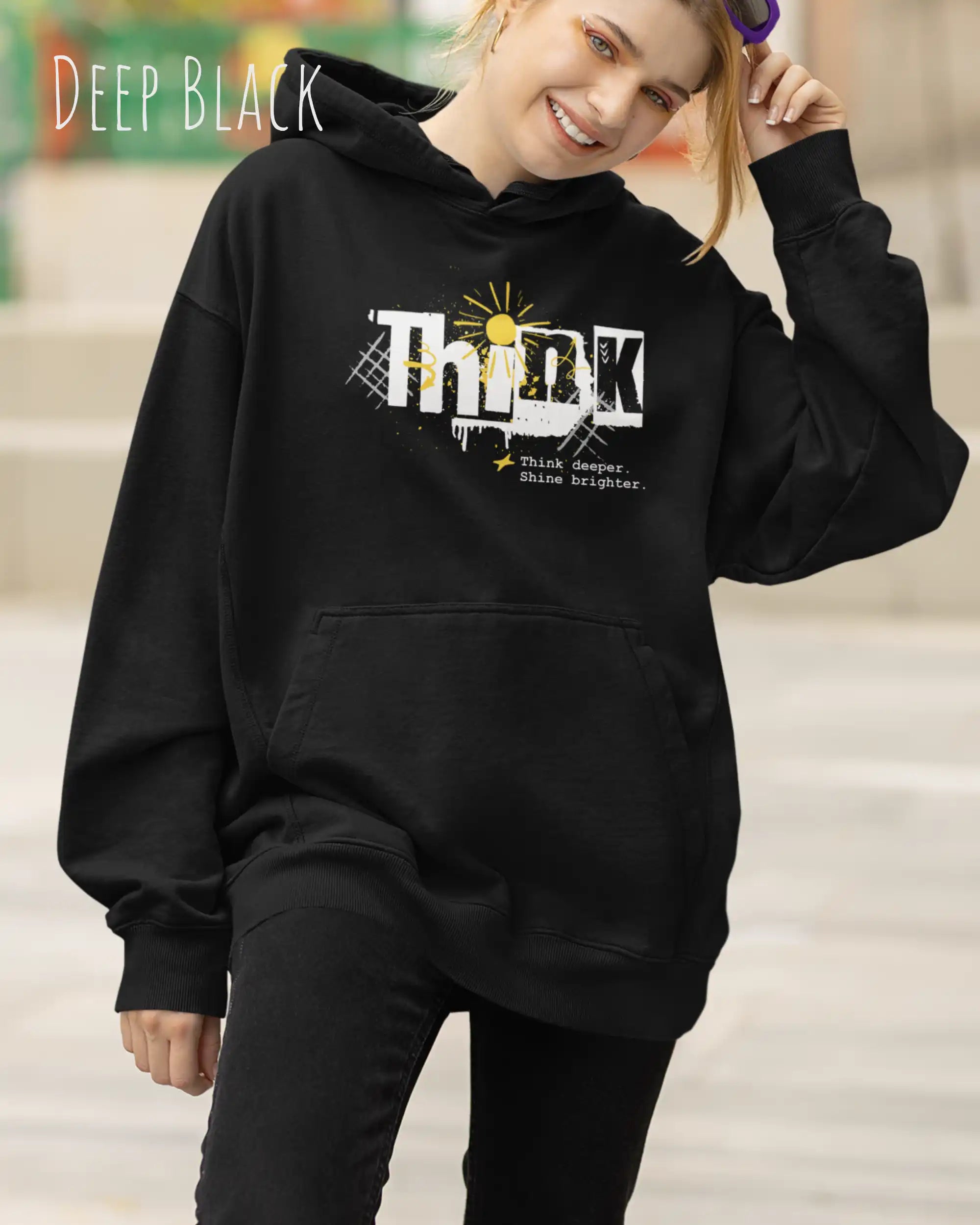 frau  trägt streetwear hoodie im oversize fit in farbe deep black mit think motiv auf der Brust