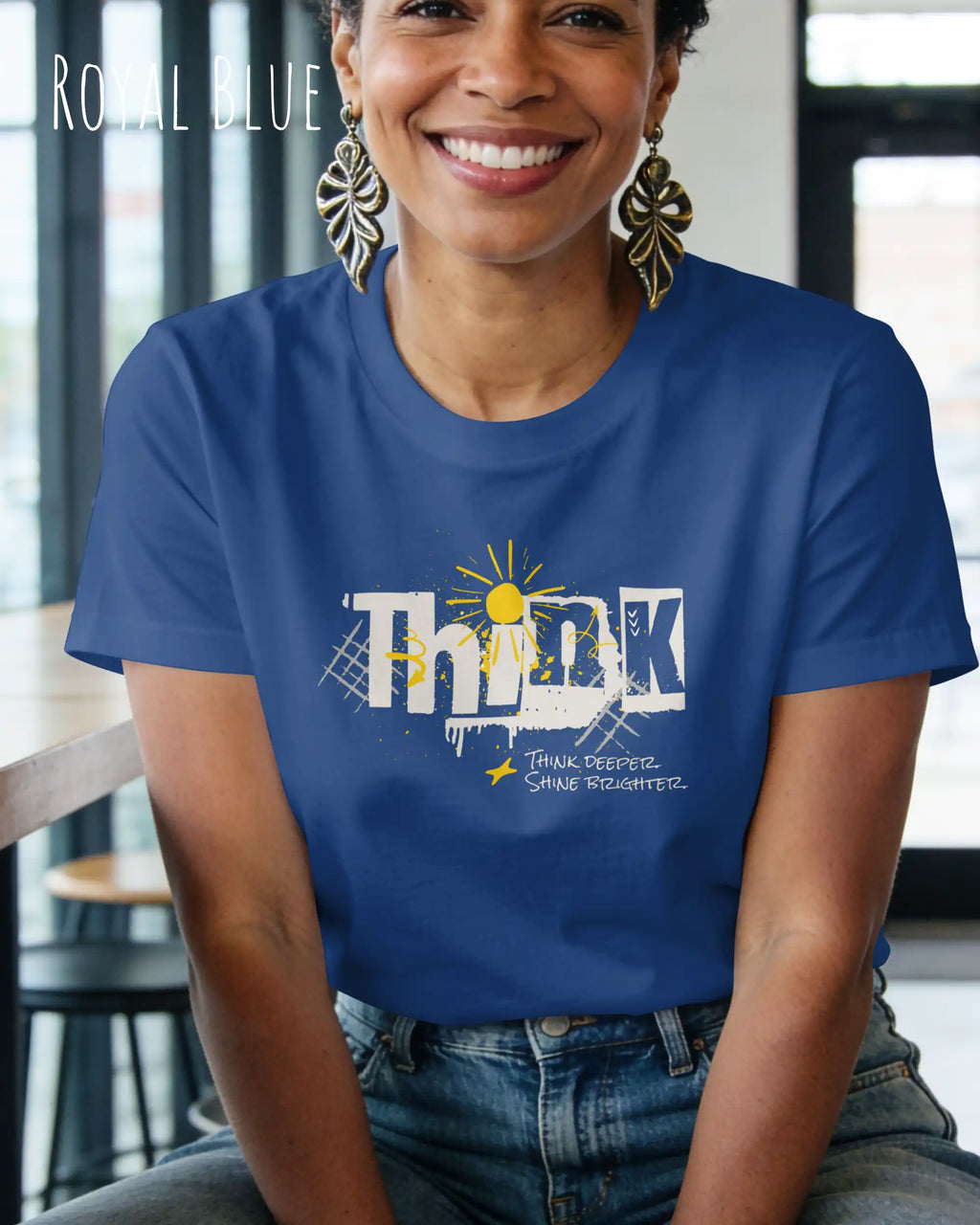 eine frau trägt ein design-t-shirt mit figurbetontem schnitt in der farbe royal blue mit dem Motiv "think deeper shine brighter"