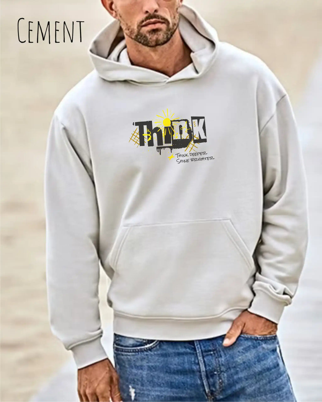 Mann trägt das Tee Jays Heavy Loose Fit Hooded Sweatshirt 5162 in der Farbe Cement Mut dem Statement Design THINK auf der Brust.