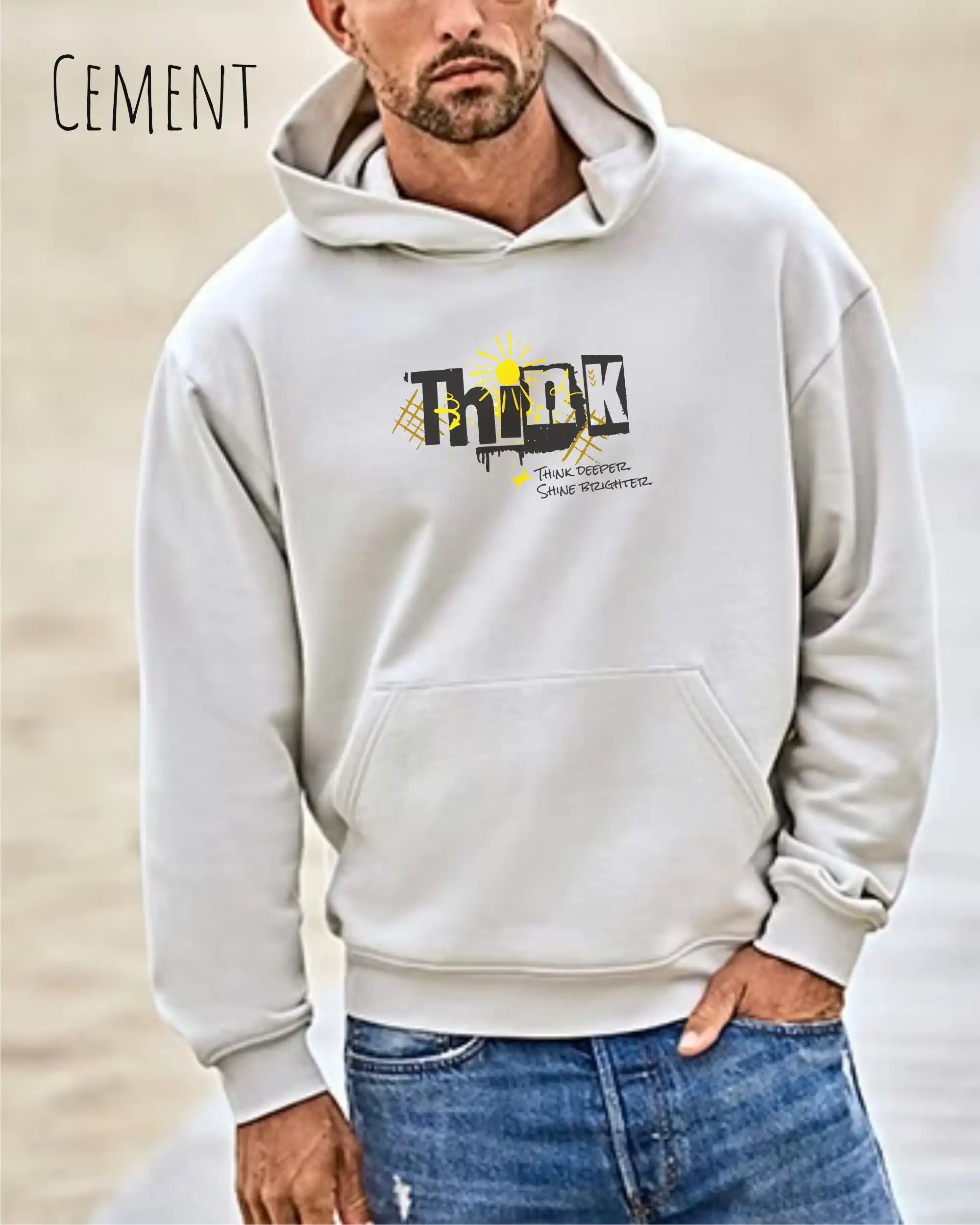 Mann trägt das Tee Jays Heavy Loose Fit Hooded Sweatshirt 5162 in der Farbe Cement Mut dem Statement Design THINK auf der Brust.