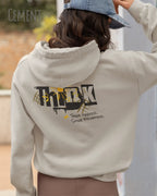 Frau  trägt das Tee Jays Heavy Loose Fit Hooded Sweatshirt 5162 in der Farbe Cement mit dem Statement Design THINK als Backprint.