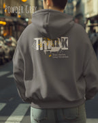 Mann  trägt das Tee Jays Heavy Loose Fit Hooded Sweatshirt 5162 in der Farbe powder grey mit dem Statement Design THINK als Backprint.