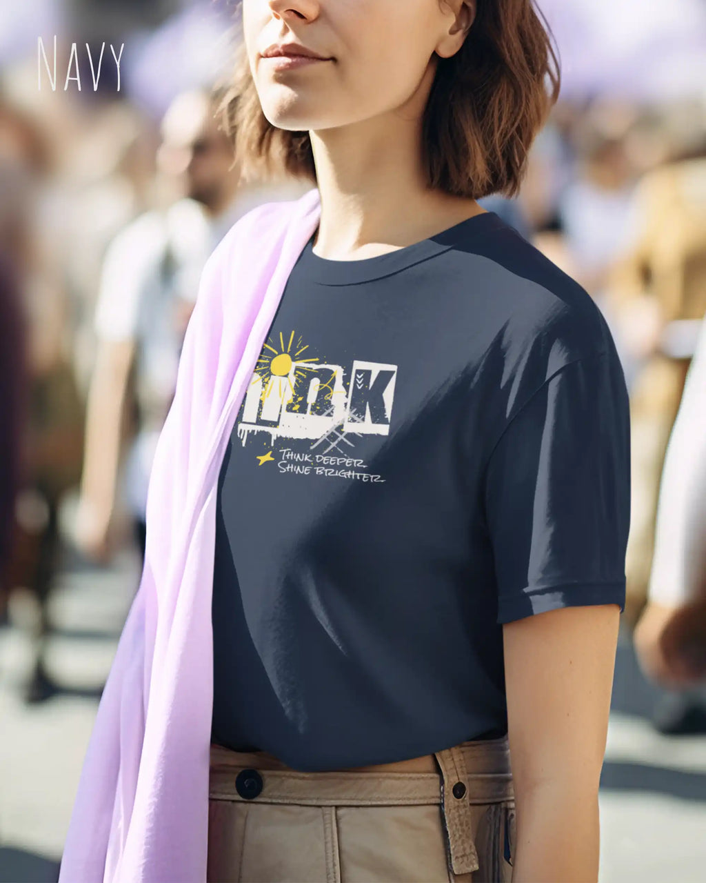 Das Bild zeigt eine frau, die ein feminines Grafik t-shirt in navy und mit dem Statement-design think deeper trägt.