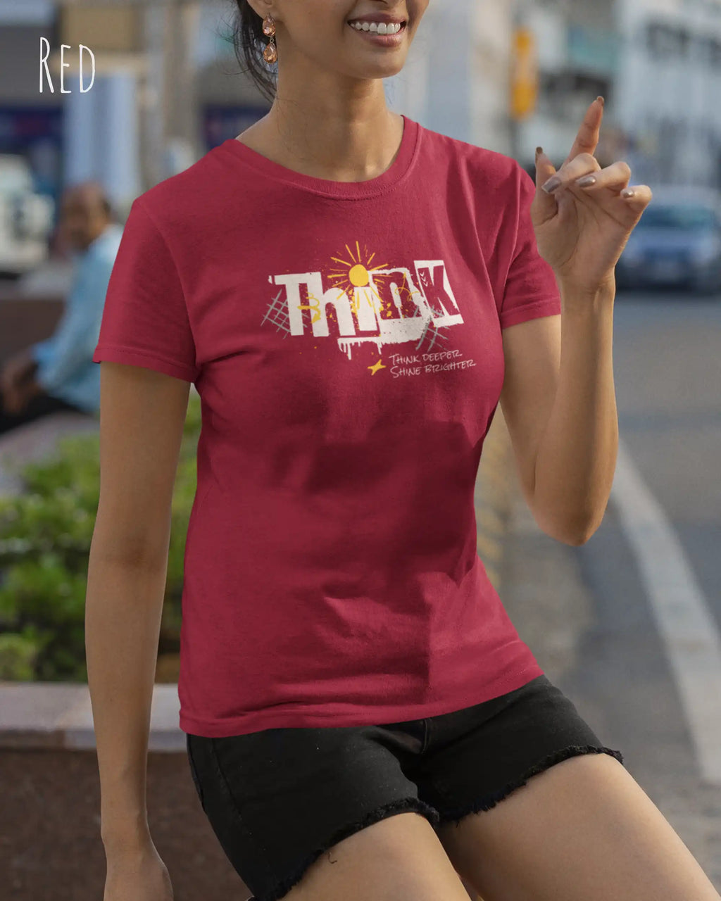 Das Bild zeigt eine frau, die ein feminines Grafik t-shirt in red und mit dem Statement-design think deeper trägt.