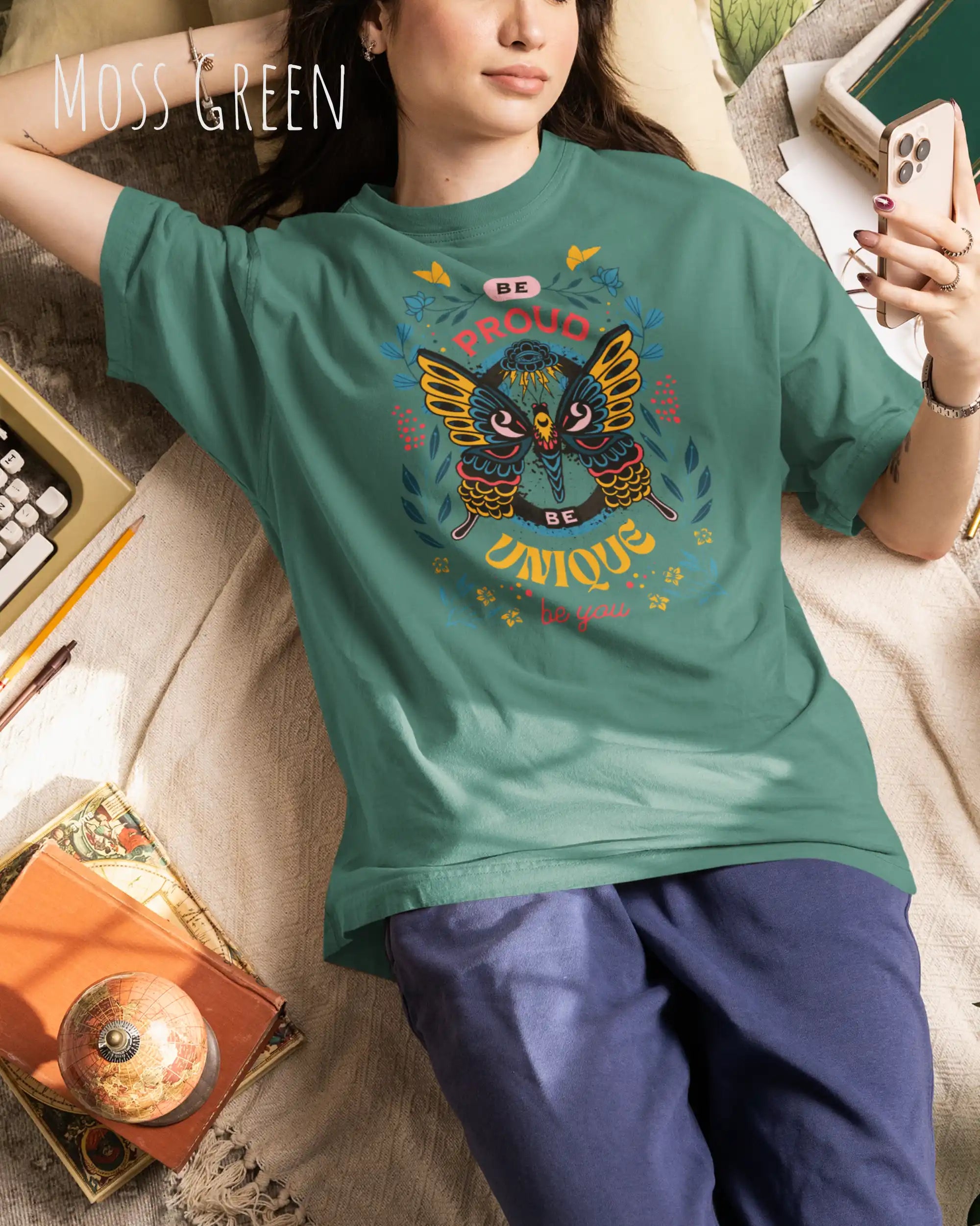 Junge Frau trägt das Heavyweight Oversized T-Shirt AWDis 240 T in der Farbe moss green mit dem Design BE PROUD BE YOU auf der Brust.