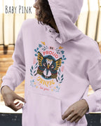 Frau trägt hoodie im feminine fit aus weicher baumwollmischung in farbe baby pink mit be proud motiv auf der Brust
