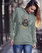 Frau trägt hoodie im feminine fit aus weicher baumwollmischung in farbe duxty green mit be proud motiv auf der Brust