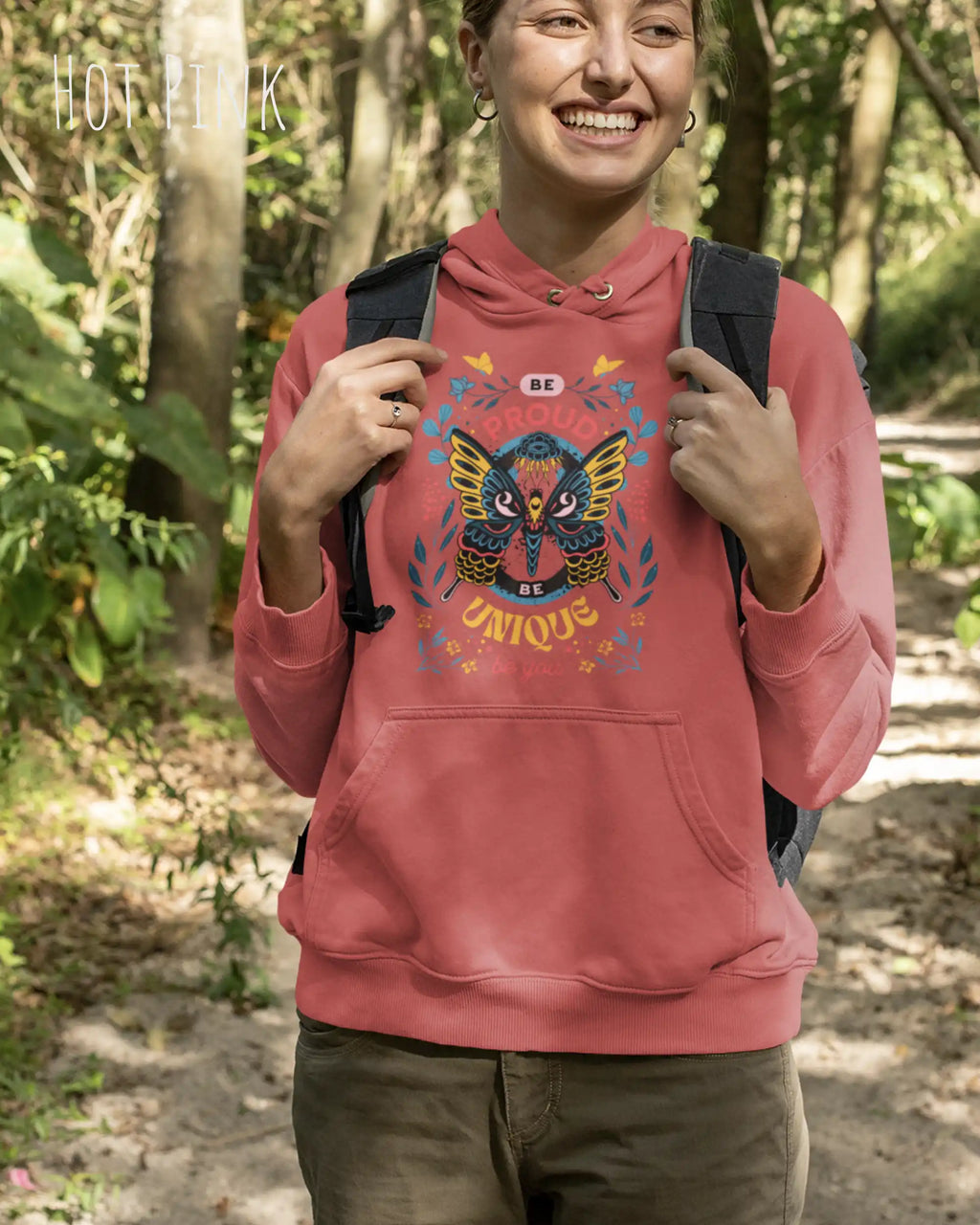 Frau trägt hoodie im feminine fit aus weicher baumwollmischung in farbe hot pink mit be proud motiv auf der Brust