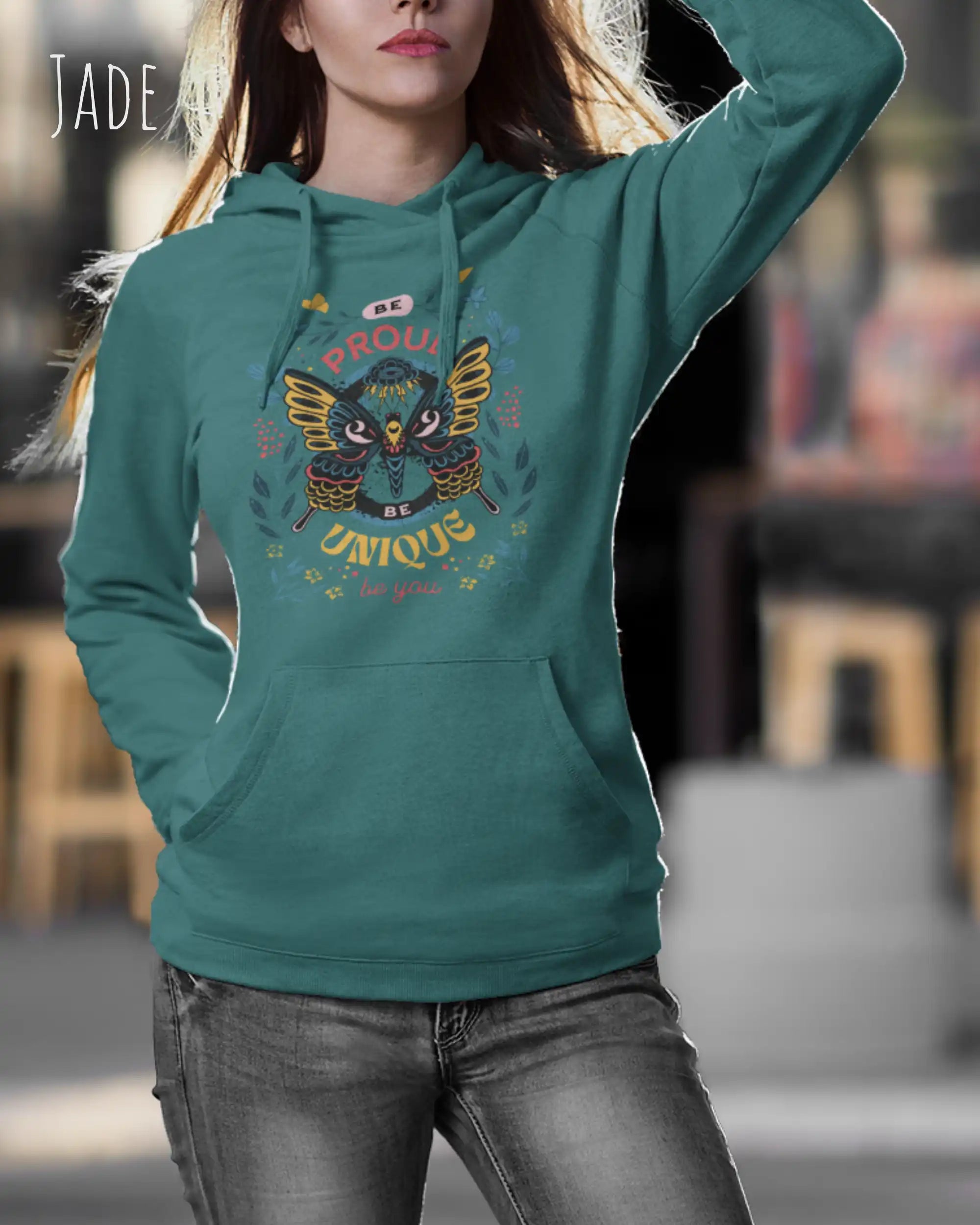 Frau trägt hoodie im feminine fit aus weicher baumwollmischung in farbe jade mit be proud motiv auf der Brust