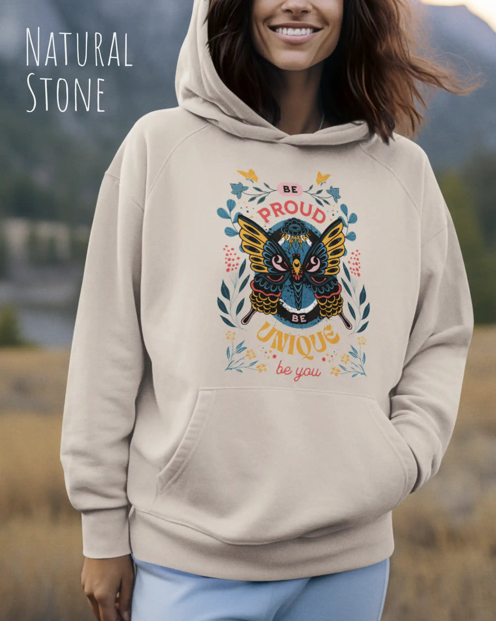  frau trägt streetwear hoodie im oversize fit in farbe natural stone mit be proud motiv auf der Brust