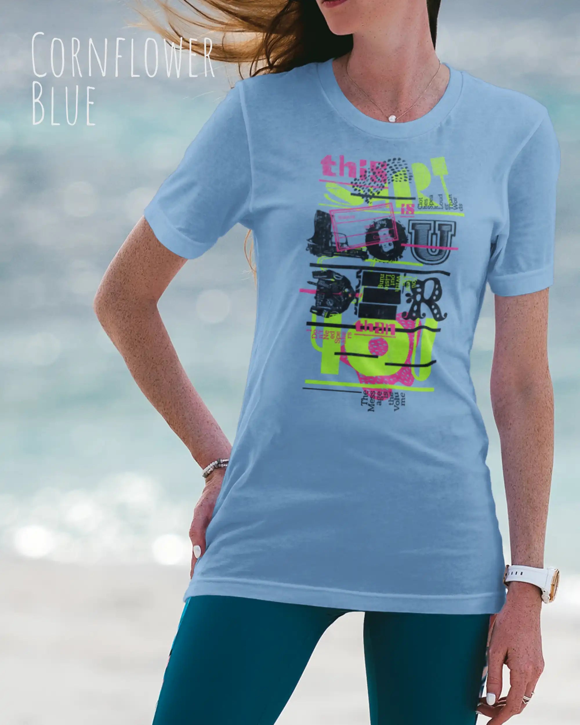 Frau trägt das leichte Sommer T-Shirt aus Baumwolle AWDis 150 T in der Farbe CORNFLOWER BLUE mit dem Design LOUDER auf der Brust.