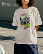 Frau trägt das Heavyweight Oversized T-Shirt AWDis 240 T in der Farbe natural stone mit dem Design LOUDER auf der Brust.