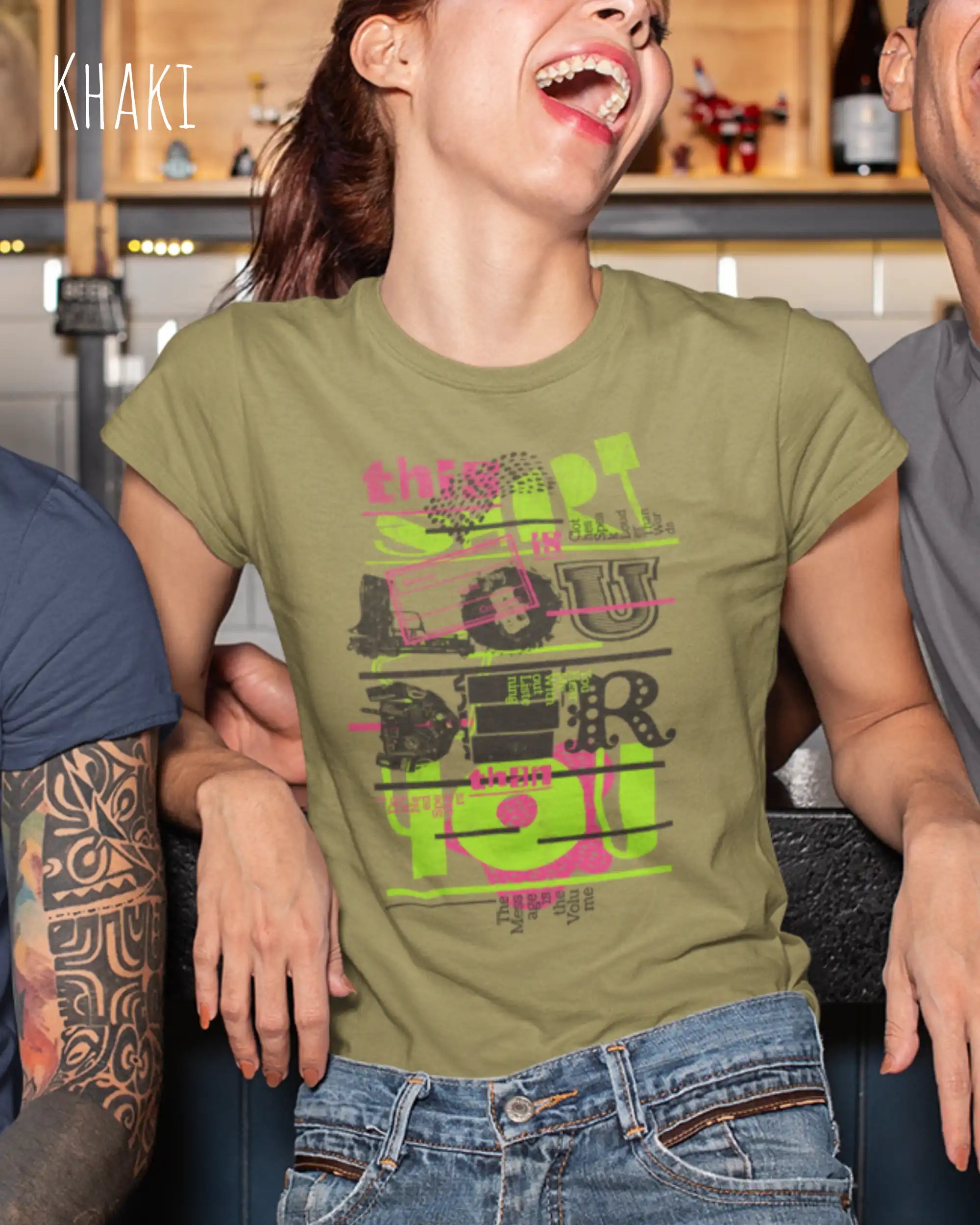 lachende frau trägt ein design-t-shirt mit tailliertem schnitten in der farbe khaki mit dem Motiv "this shirt is louder ..."