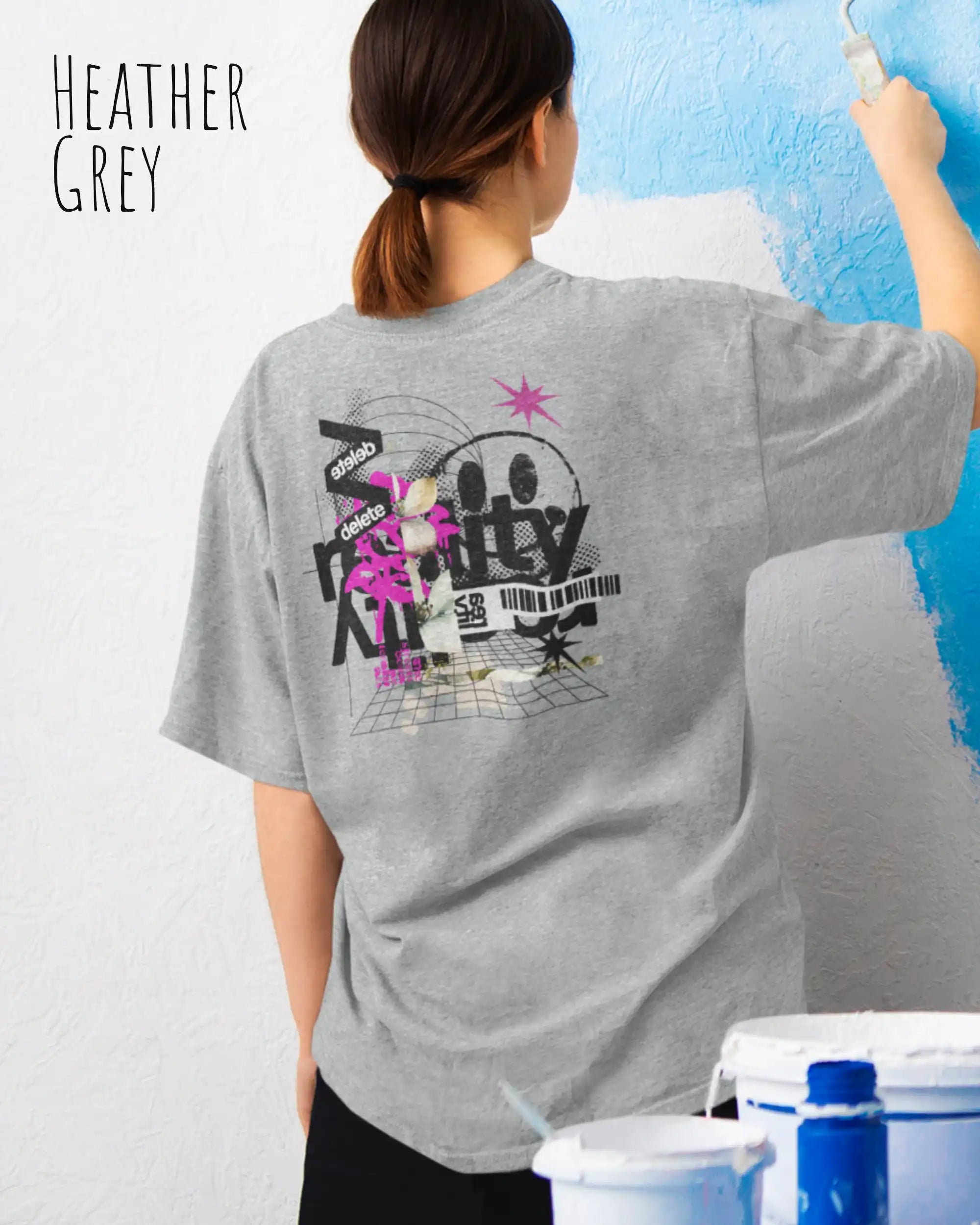 Frau trägt das Heavyweight Oversized T-Shirt AWDis 240 T in der Farbe arctic white mit dem Design DELETE REALITY auf dem Rücken.