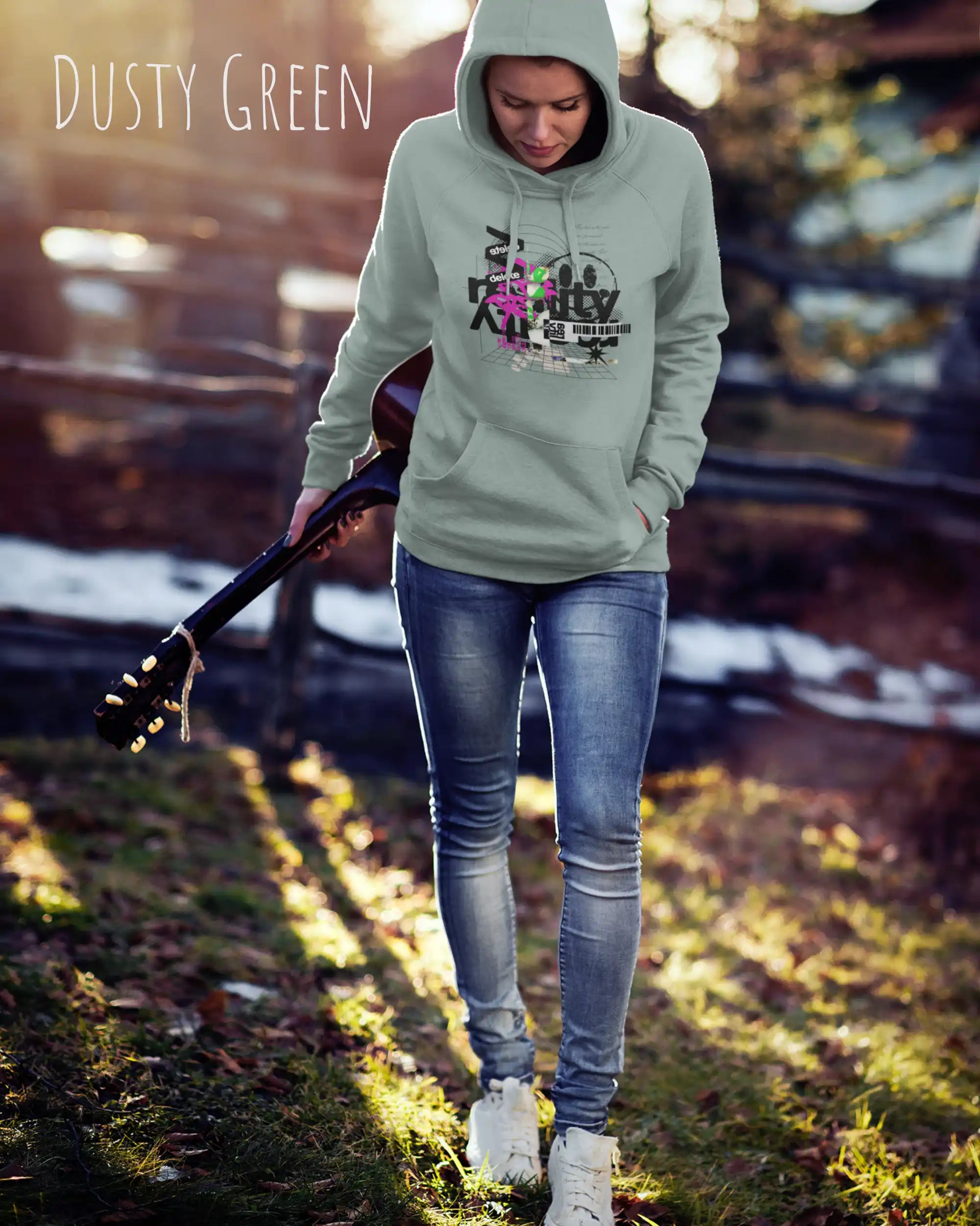 Frau trägt hoodie im feminine fit aus weicher baumwollmischung in farbe dusty green mit delete reality motiv auf der Brust