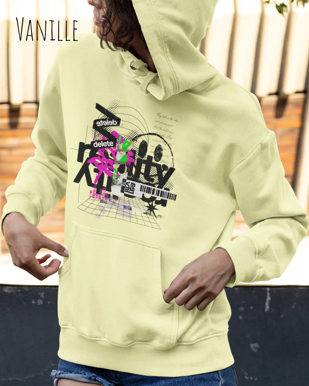 Frau trägt hoodie im feminine fit aus weicher baumwollmischung in farbe Vanille mit delete reality motiv auf der Brust