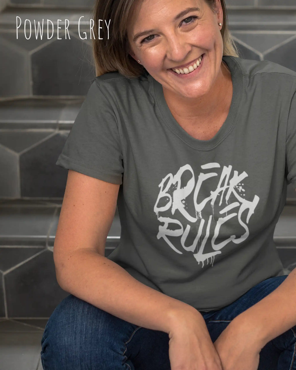 Frau trägt das Bio-Baumwolle T-Shirt Tee Jays Urban Luxury Tee 1150 in der Farbe powder grey mit dem Design BREAK RULES auf der Brust.