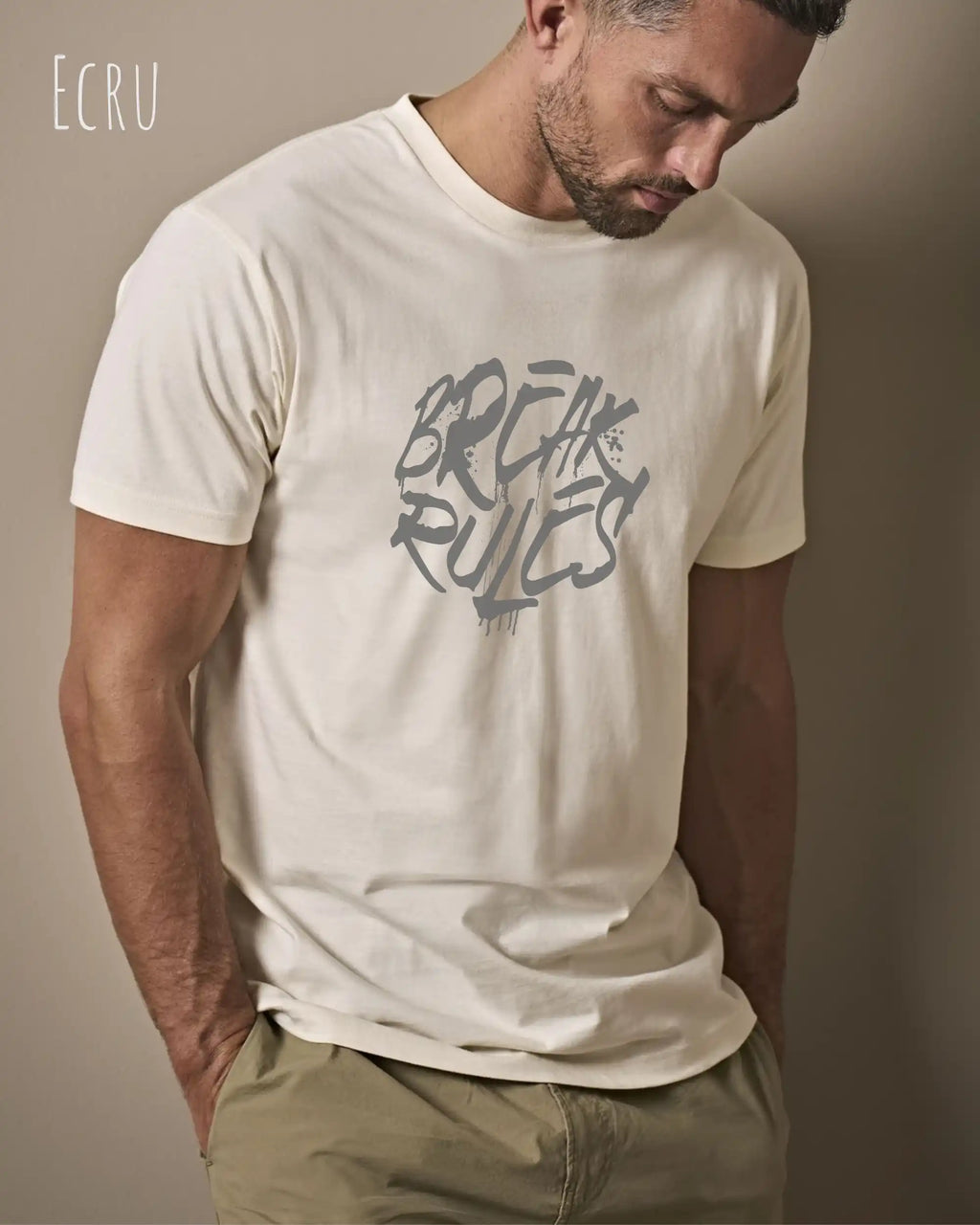 Mann trägt das Bio-Baumwolle T-Shirt Tee Jays Urban Luxury Tee 1150 in der Farbe ecru mit dem Design BREAK RULES auf der Brust.