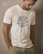 Mann trägt das Bio-Baumwolle T-Shirt Tee Jays Urban Luxury Tee 1150 in der Farbe ecru mit dem Design BREAK RULES auf der Brust.