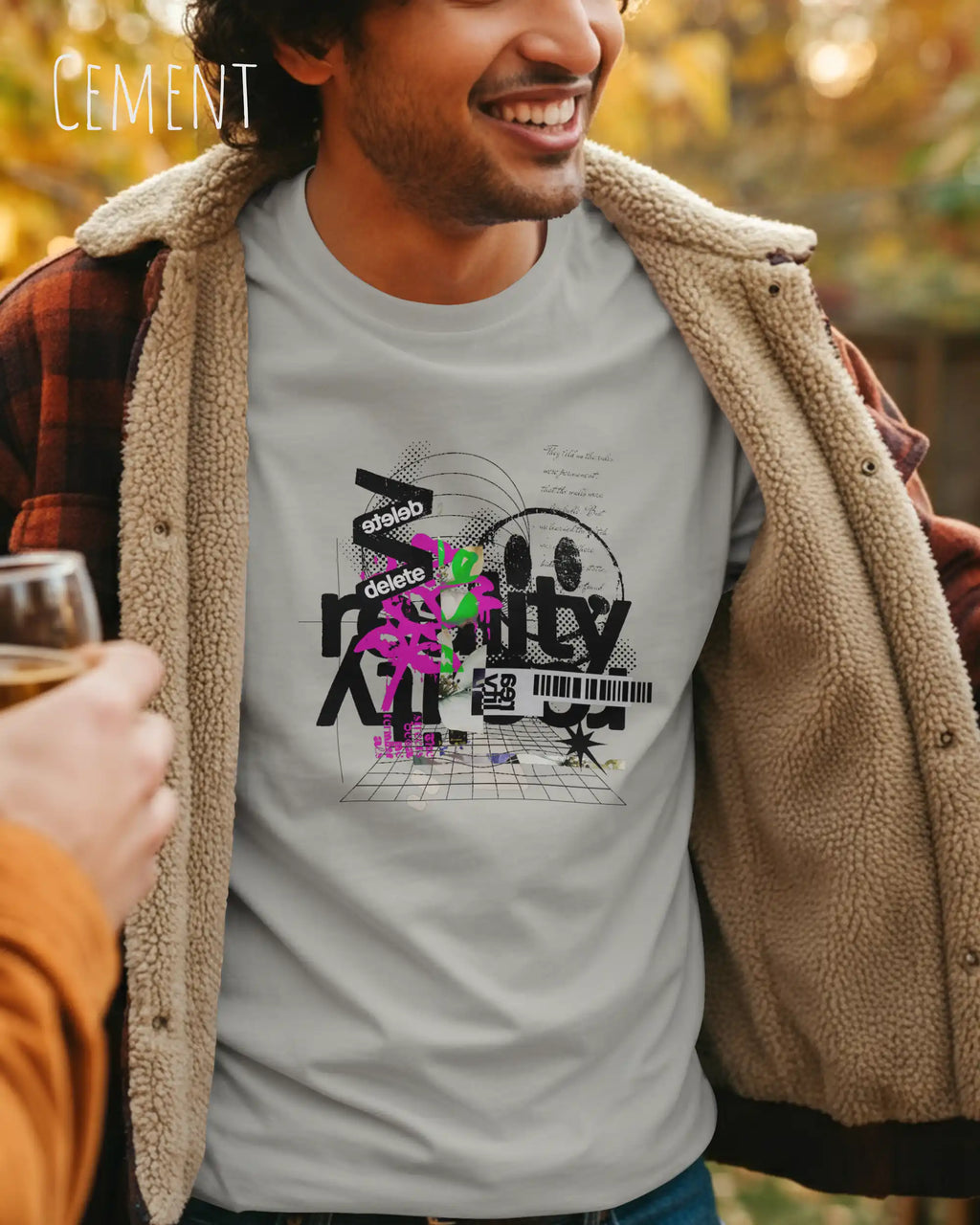 Mann trägt das Bio-Baumwolle T-Shirt Tee Jays Urban Luxury Tee 1150 in der Farbe cement mit dem Design DELETE REALITY auf der Brust.