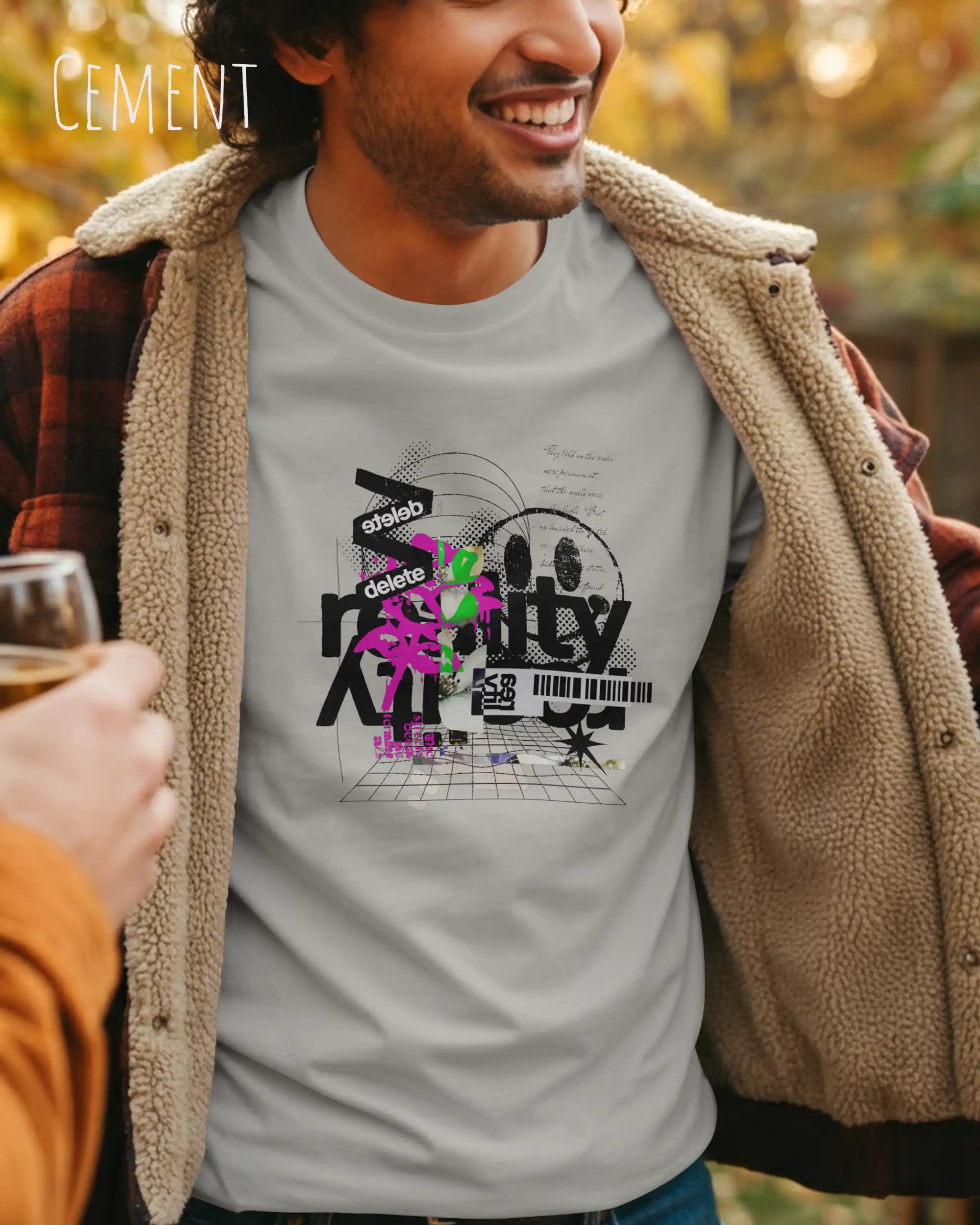 Mann trägt das Bio-Baumwolle T-Shirt Tee Jays Urban Luxury Tee 1150 in der Farbe cement mit dem Design DELETE REALITY auf der Brust.