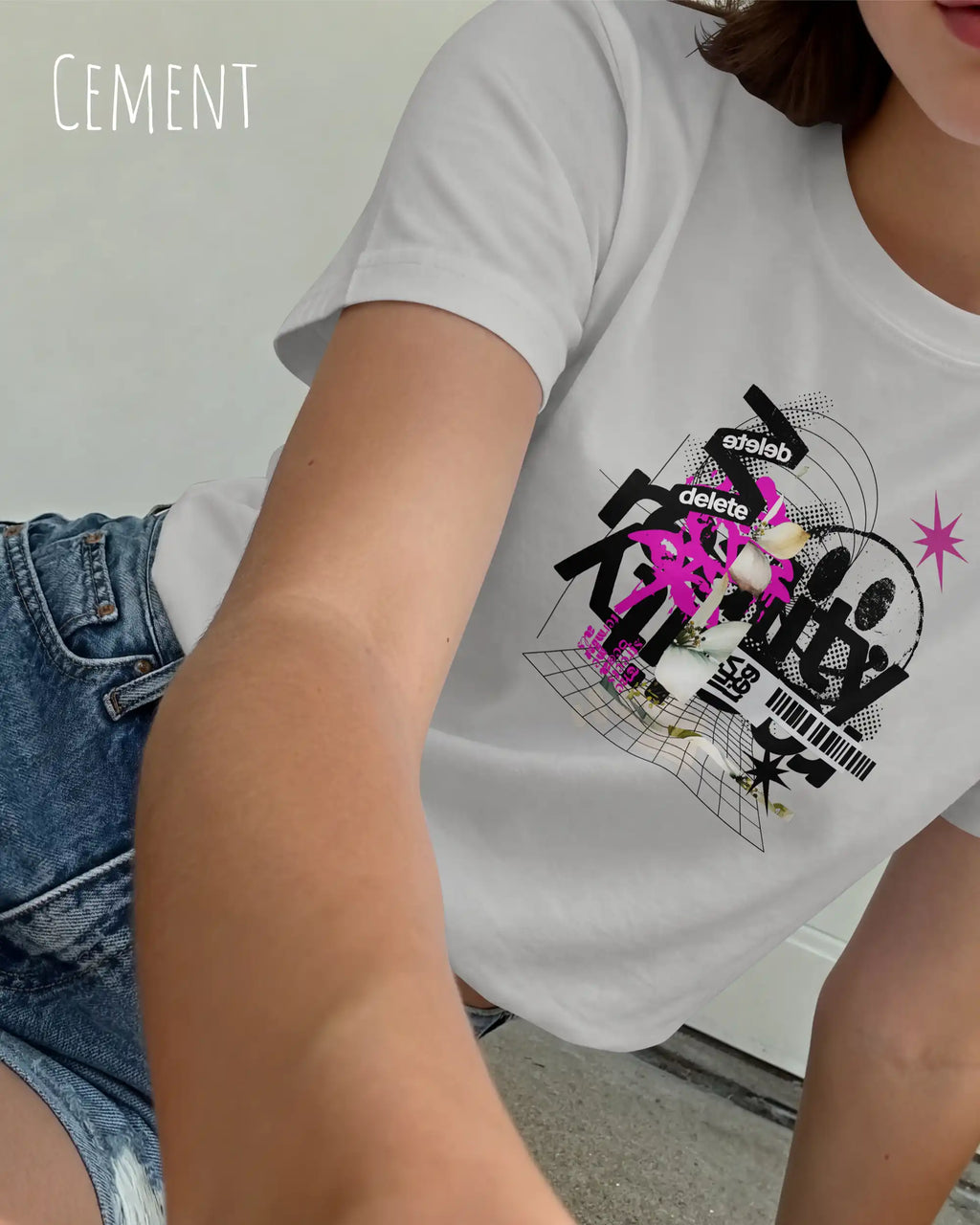 Eine junge frau trägt ein design t-shirt mit femininem schnitt in der farbe cement und mit der grafik "delete reality".