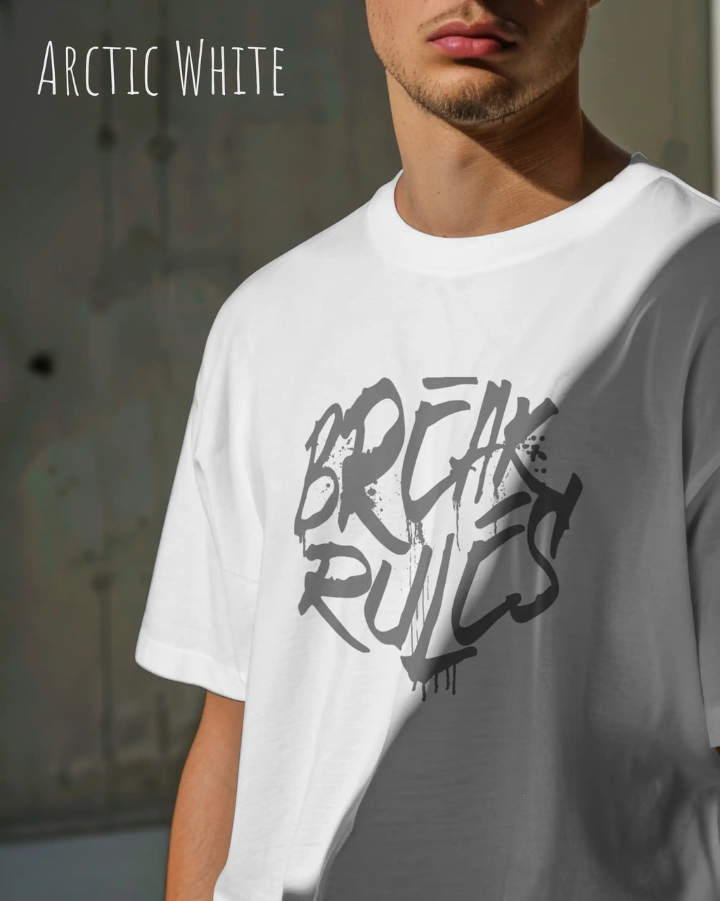Mann trägt das leichte Sommer T-Shirt aus Baumwolle AWDis 150 T in der Farbe ARCTIC WHITE mit dem Design BREAK RULES auf der Brust.