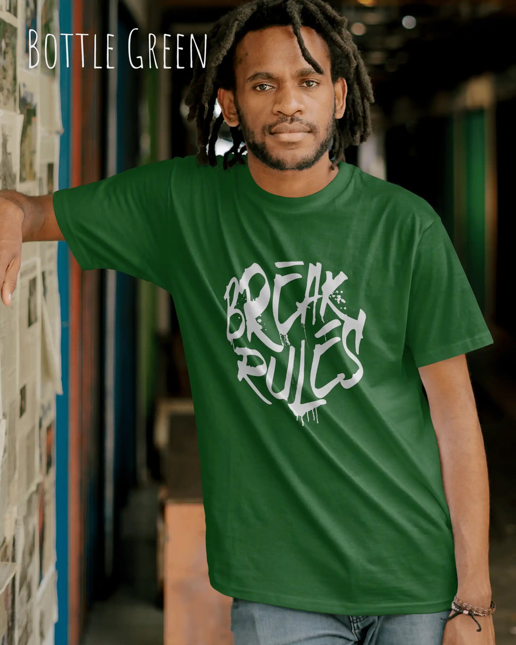 Mann trägt das leichte Sommer T-Shirt aus Baumwolle AWDis 150 T in der Farbe BOTTLE GREEN mit dem Design BREAK RULES auf der Brust.