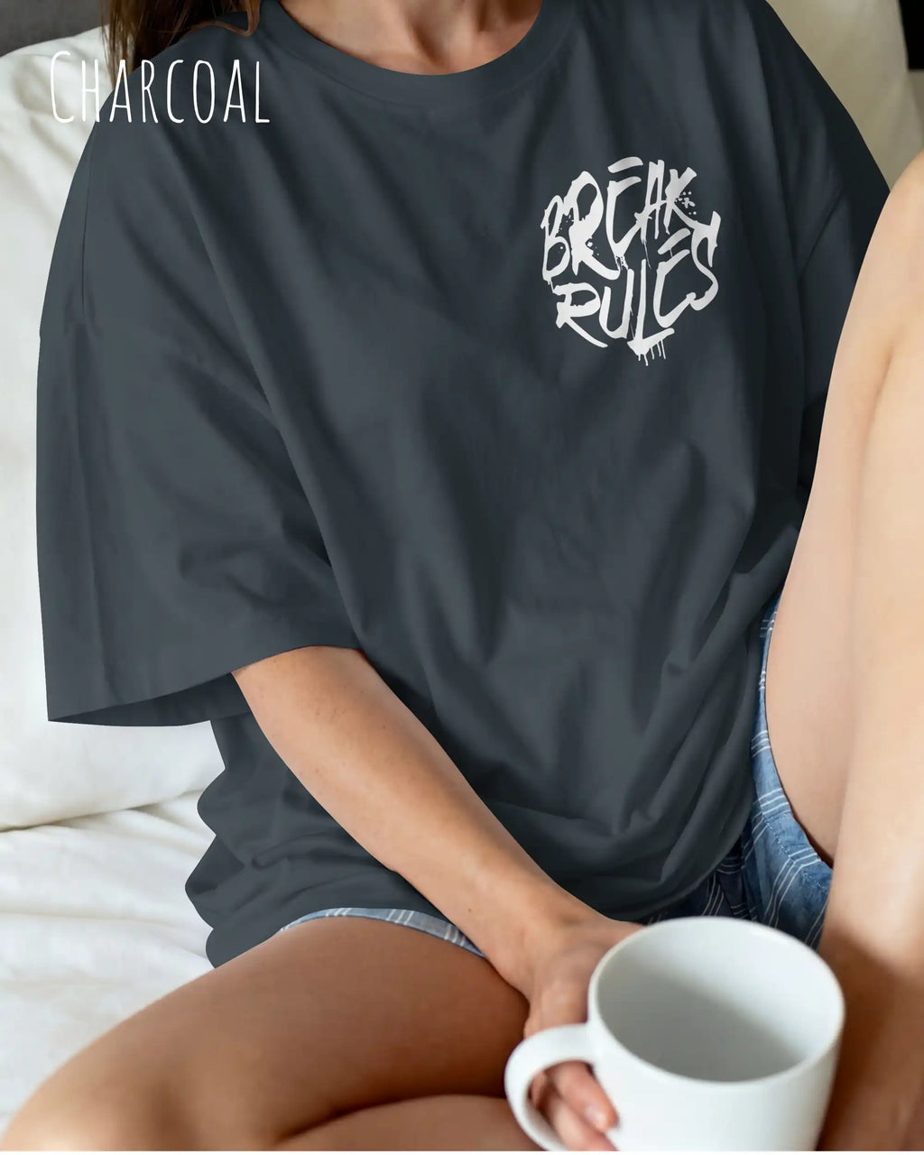 frau trägt ein oversized heavyweight design-t-shirt in der farbe charcoal mit dem motiv break rules oben links