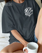 frau trägt ein oversized heavyweight design-t-shirt in der farbe charcoal mit dem motiv break rules oben links