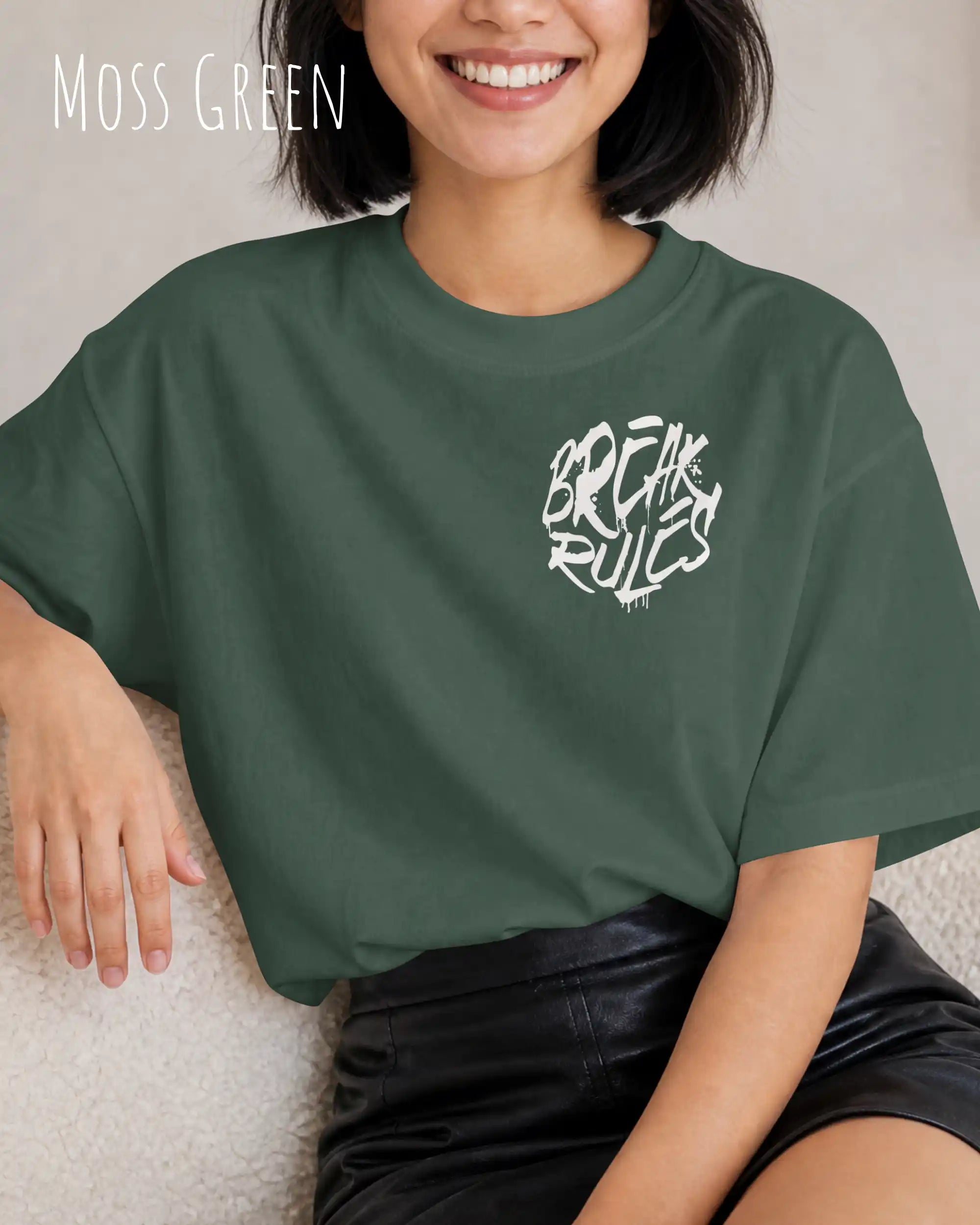 frau trägt ein oversized heavyweight design-t-shirt in der farbe moss green mit dem motiv break rules oben links