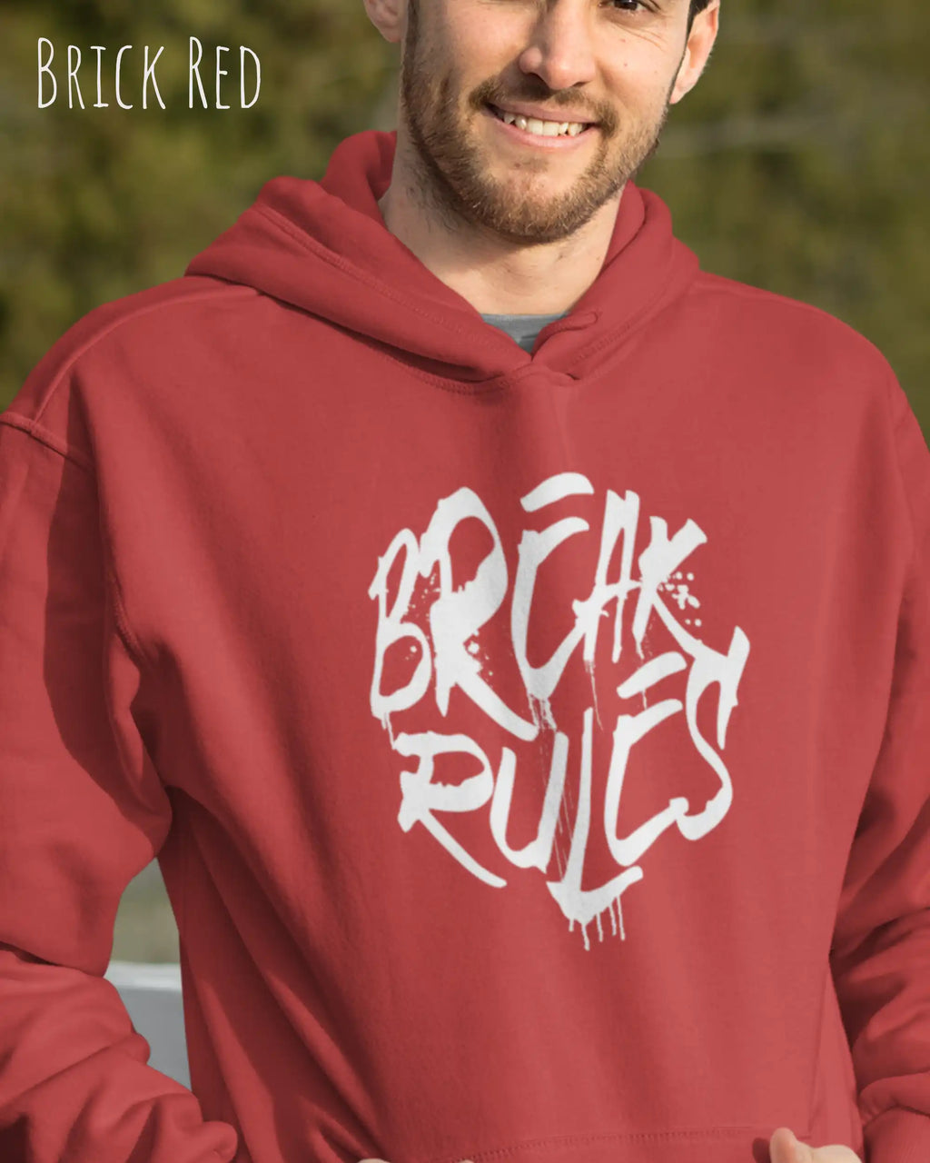 Mann trägt basic hoodie aus weicher baumwollmischung in farbe brick red mit break rules  motiv auf der Brust