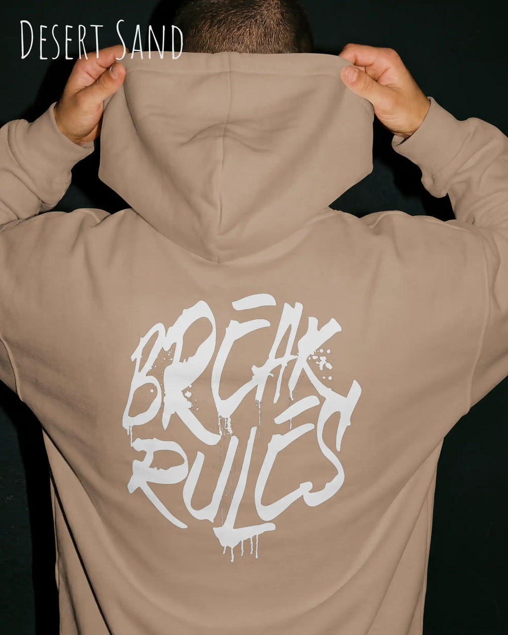 Mann trägt basic hoodie aus weicher baumwollmischung in farbe desert sand mit break rules motiv auf dem rücken