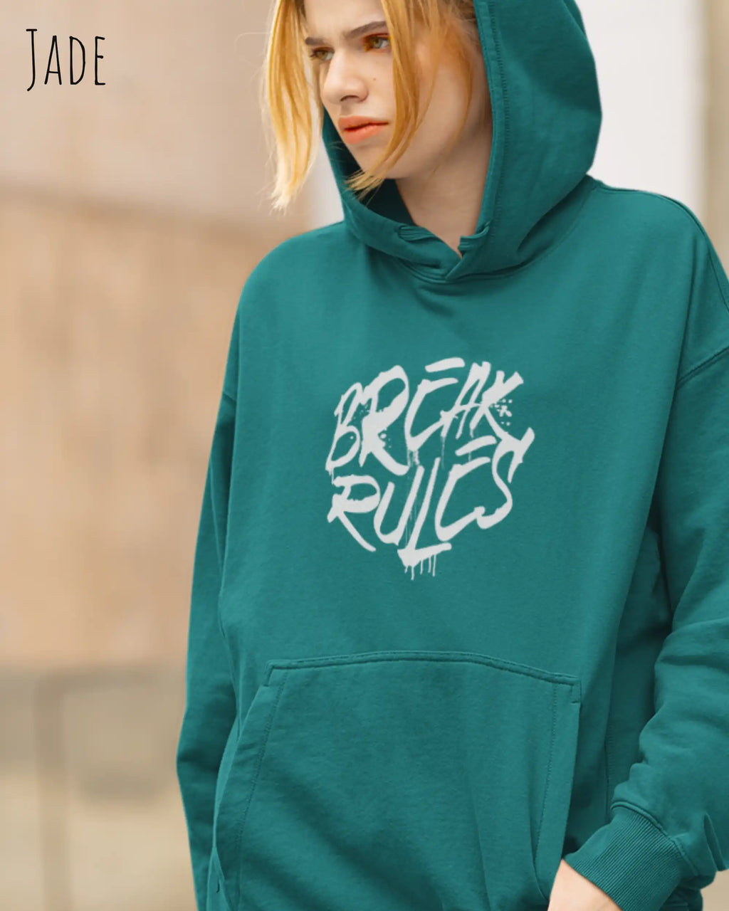 blonde frau trägt basic hoodie aus weicher baumwollmischung in farbe jade mit break rules motiv auf der Brust