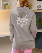 frau trägt basic hoodie aus weicher baumwollmischung in farbe Platin grey mit break rules motiv auf dem rücken