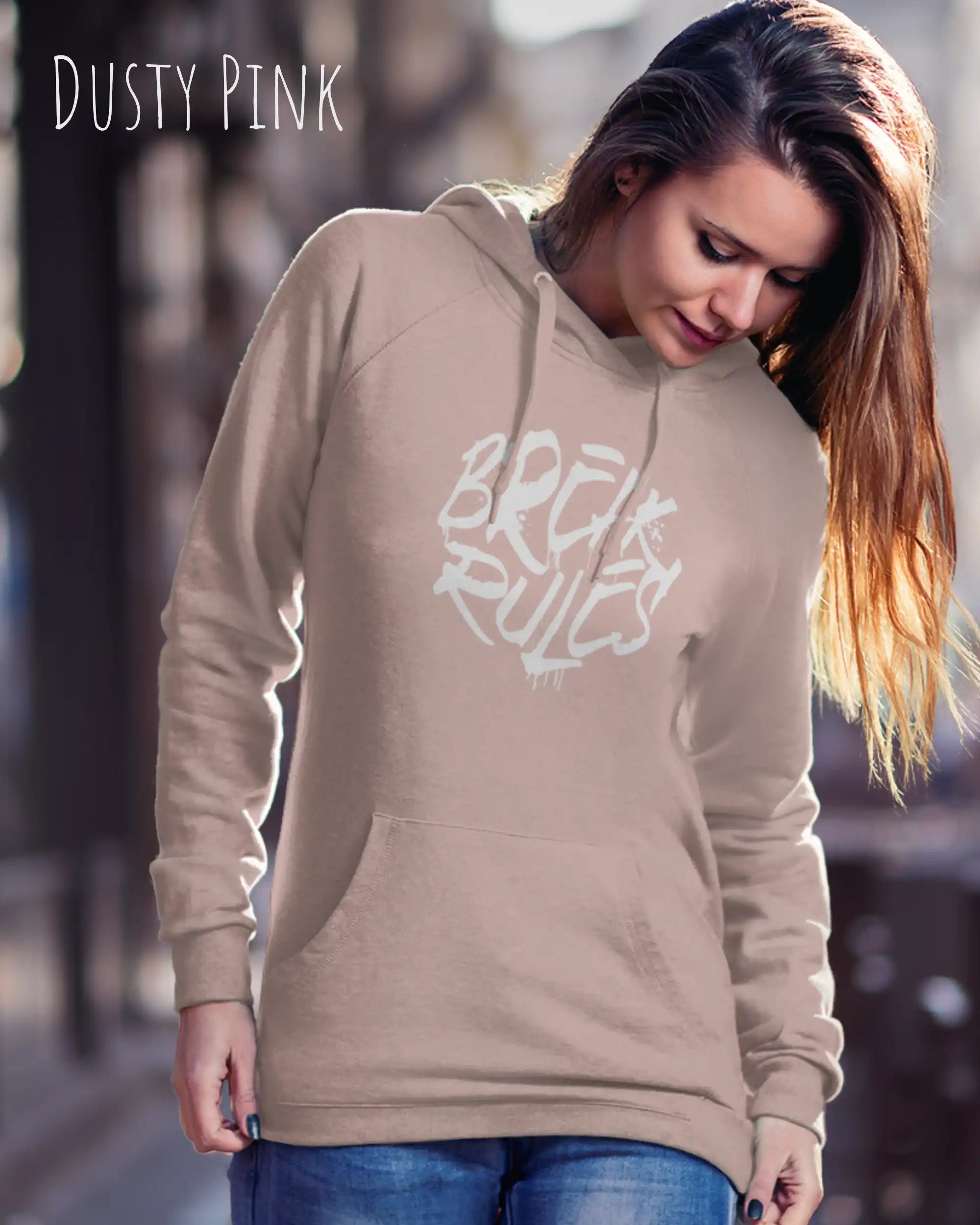 Frau trägt hoodie im feminine fit aus weicher baumwollmischung in farbe dusty pink mit break rules motiv auf der Brust
