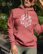 Frau trägt hoodie im feminine fit aus weicher baumwollmischung in farbe hot pink mit break rules motiv auf der Brust