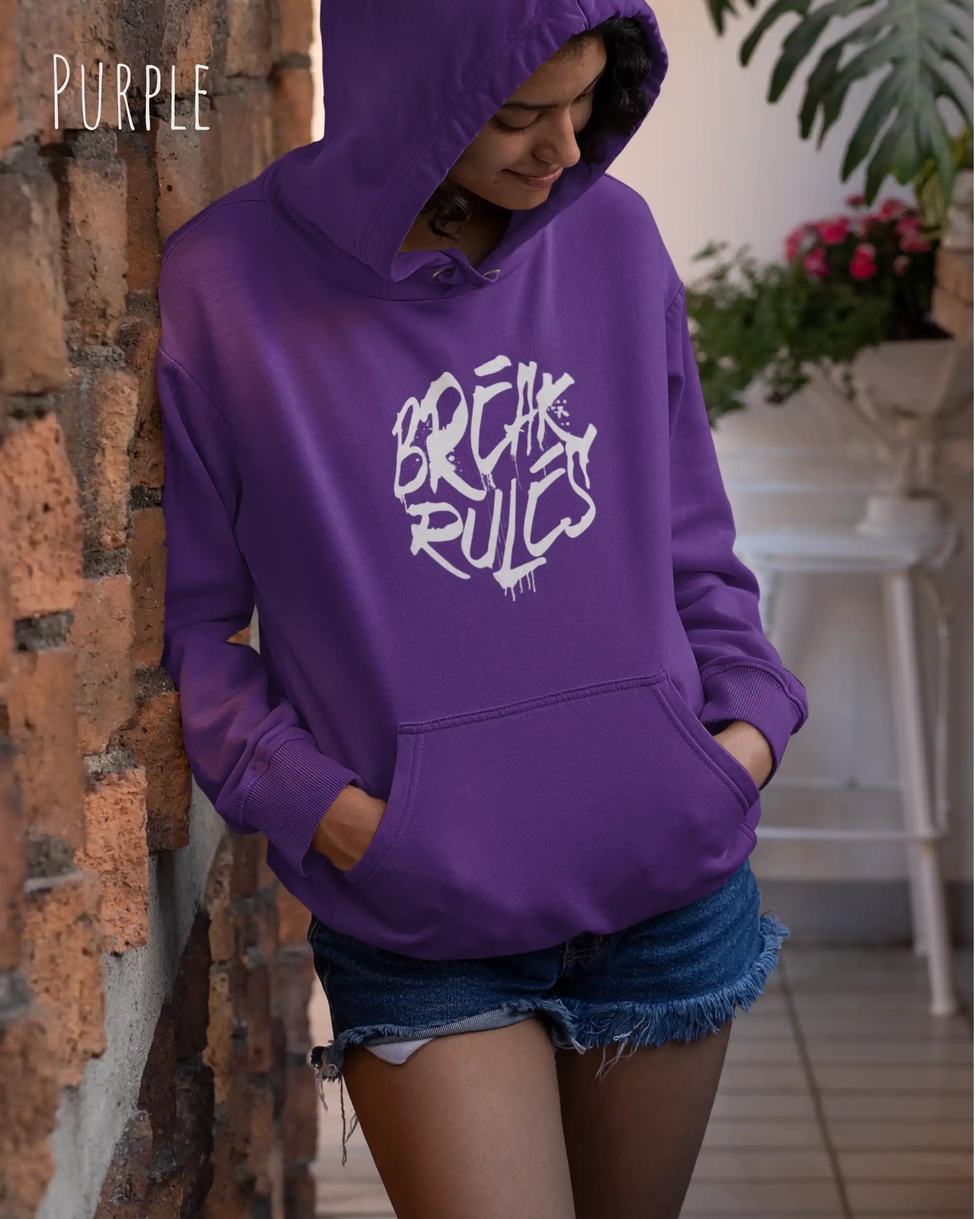 Frau trägt hoodie im feminine fit aus weicher baumwollmischung in farbe purple mit break rules motiv auf der Brust