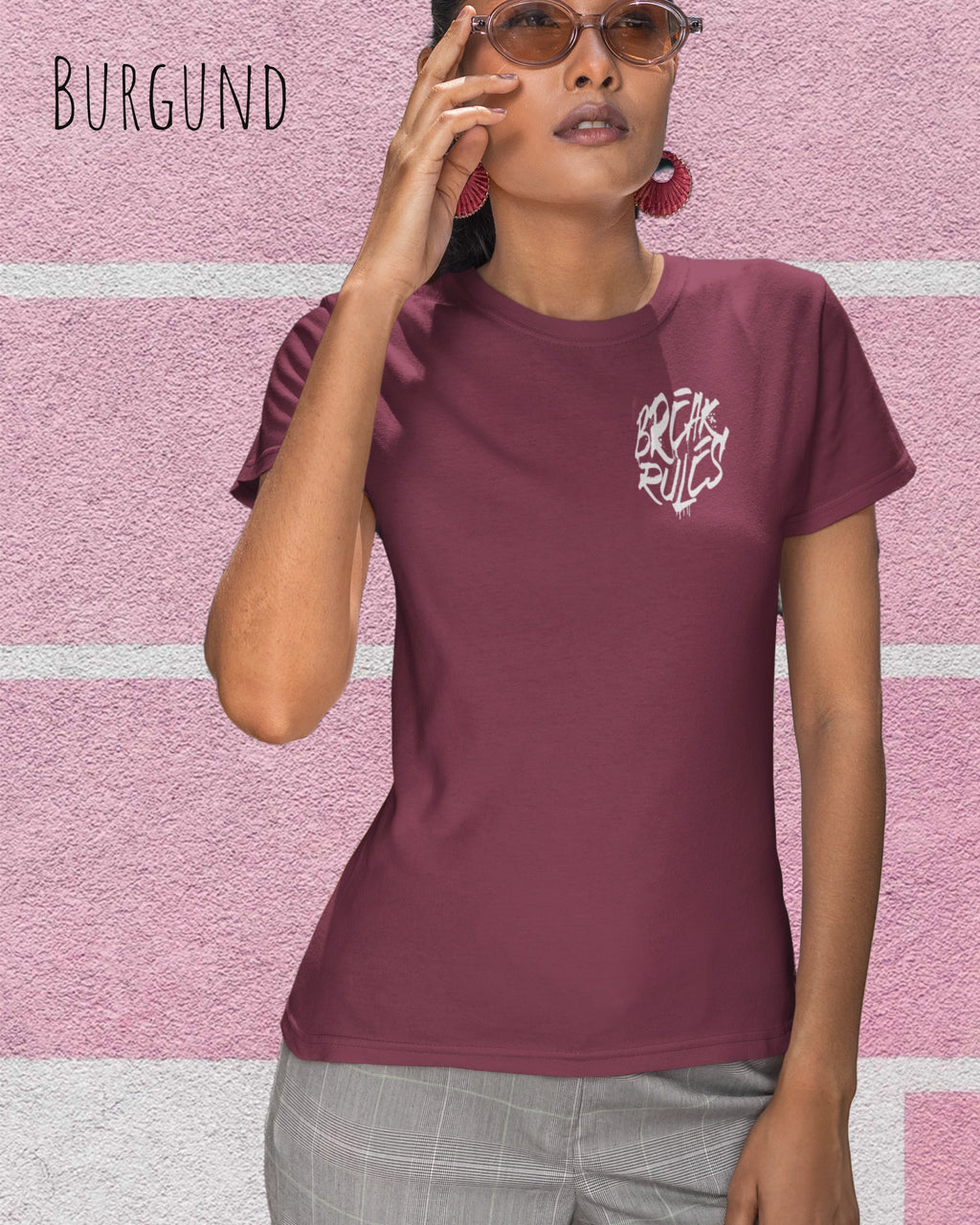 Frau trägt ein feminines Design-T-Sjhirt in der farbe Burgund mit dem Statement break rules links oben  auf der brust