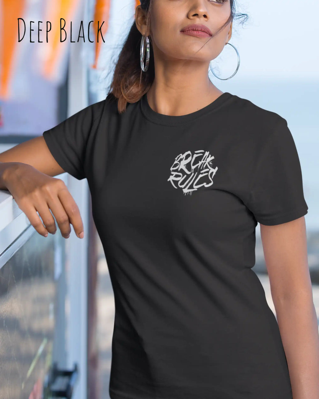 Frau trägt ein feminines Design-T-Sjhirt in der farbe deep black mit dem Statement break rules links oben  auf der brust