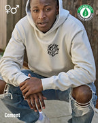 die Abbildung zeigt einen Mann, der das Tee Jays Heavy Loose Fit Hooded Sweatshirt 5162 in der farbe cmenet mit dem design "break rules" m oben links trägt..