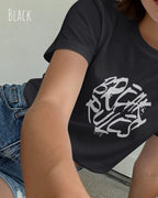 Eine  frau trägt ein design t-shirt mit femininem schnitt in der farbe black und mit der grafik "break rules" vorne auf der brust