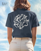 Eine  frau trägt ein design t-shirt mit femininem schnitt in der farbe navy und mit der grafik "break rules" auf dem rücken.