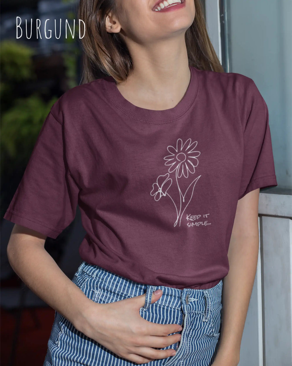 Junge Frau trägt ein design t-shirt in Burgund mit dem motiv keep it simple.