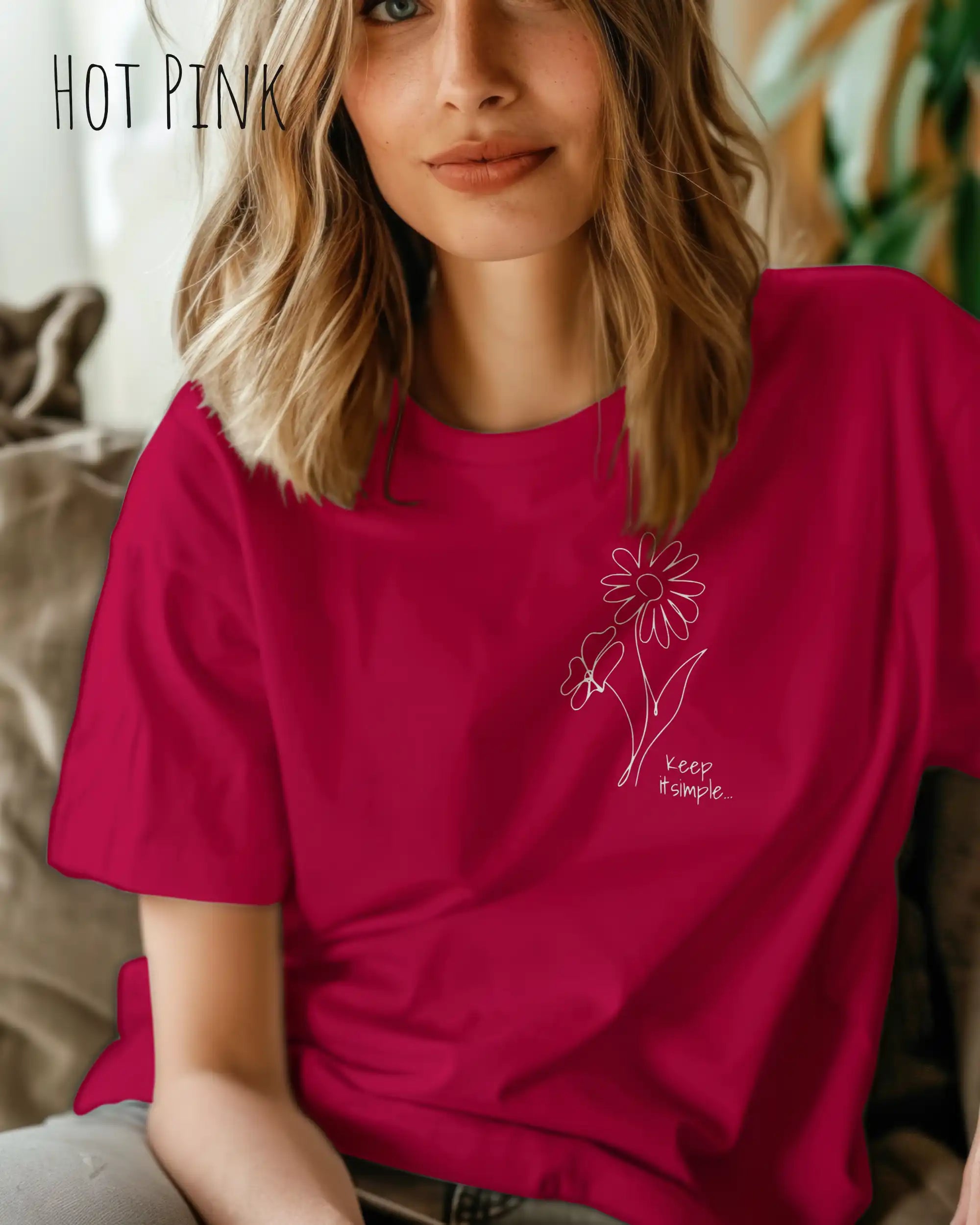 Junge Frau trägt ein design t-shirt in hot pink mit dem motiv keep it simple.
